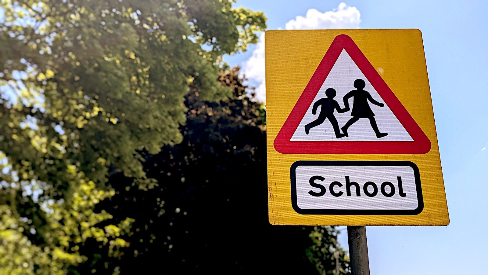School crossing warning sign with children silhouettes