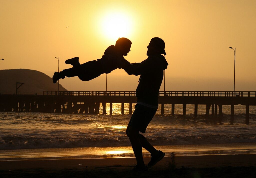 silhouette a man lifting up his child