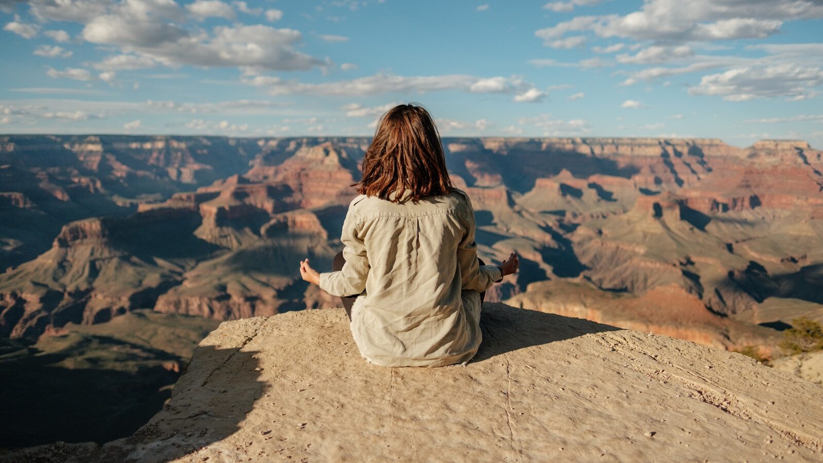 woman sits thinking on hill